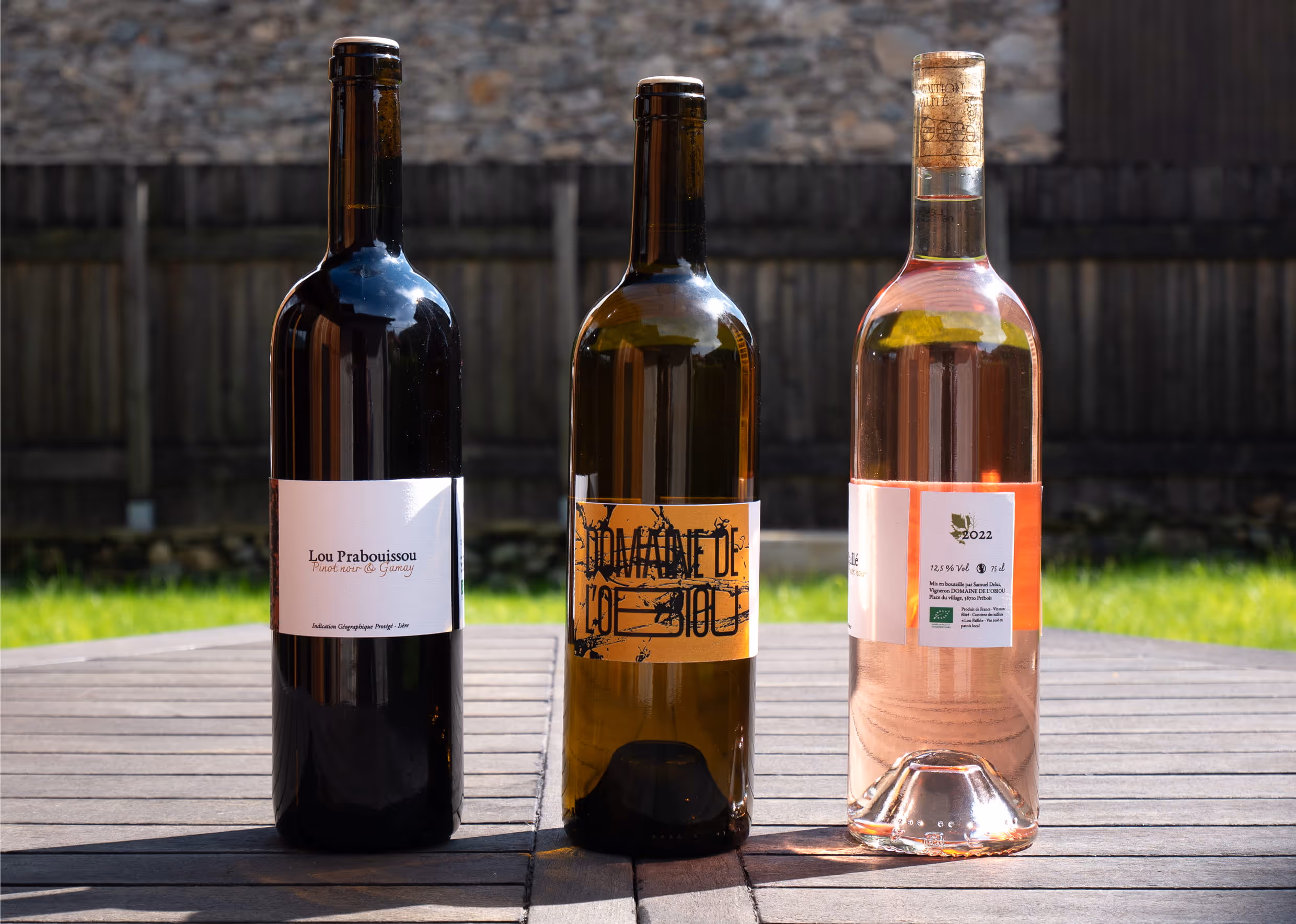 Trois bouteilles de vin du Domaine de l’Obiou, avec trois étiquettes différentes pour le vin rouge, blanc et rosé