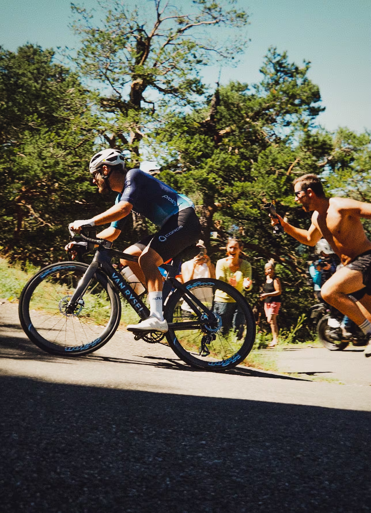 Cycliste en pleine ascension, encouragé par le public 