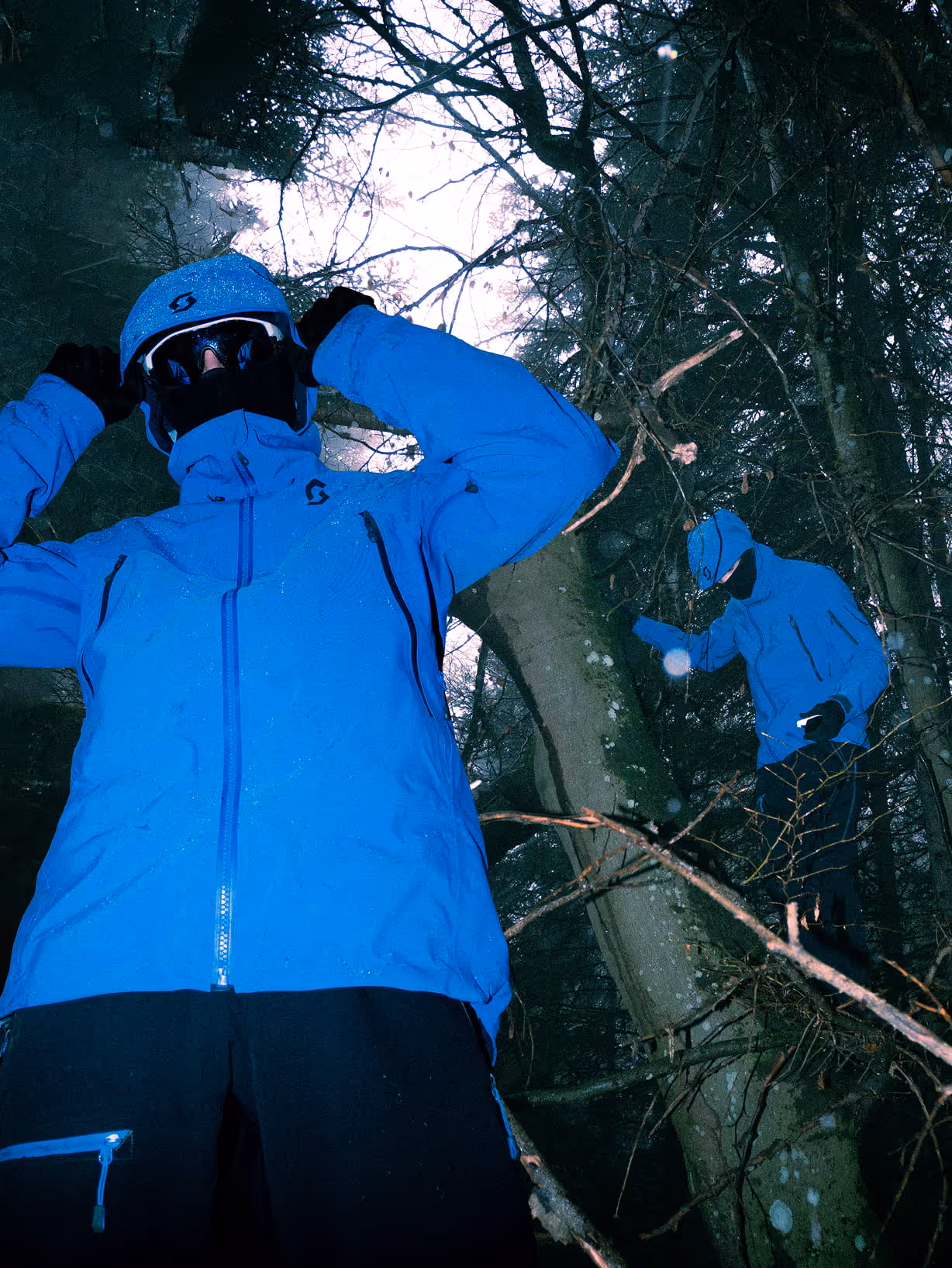 Deux personnes en pleine forêt, portant une veste Scott